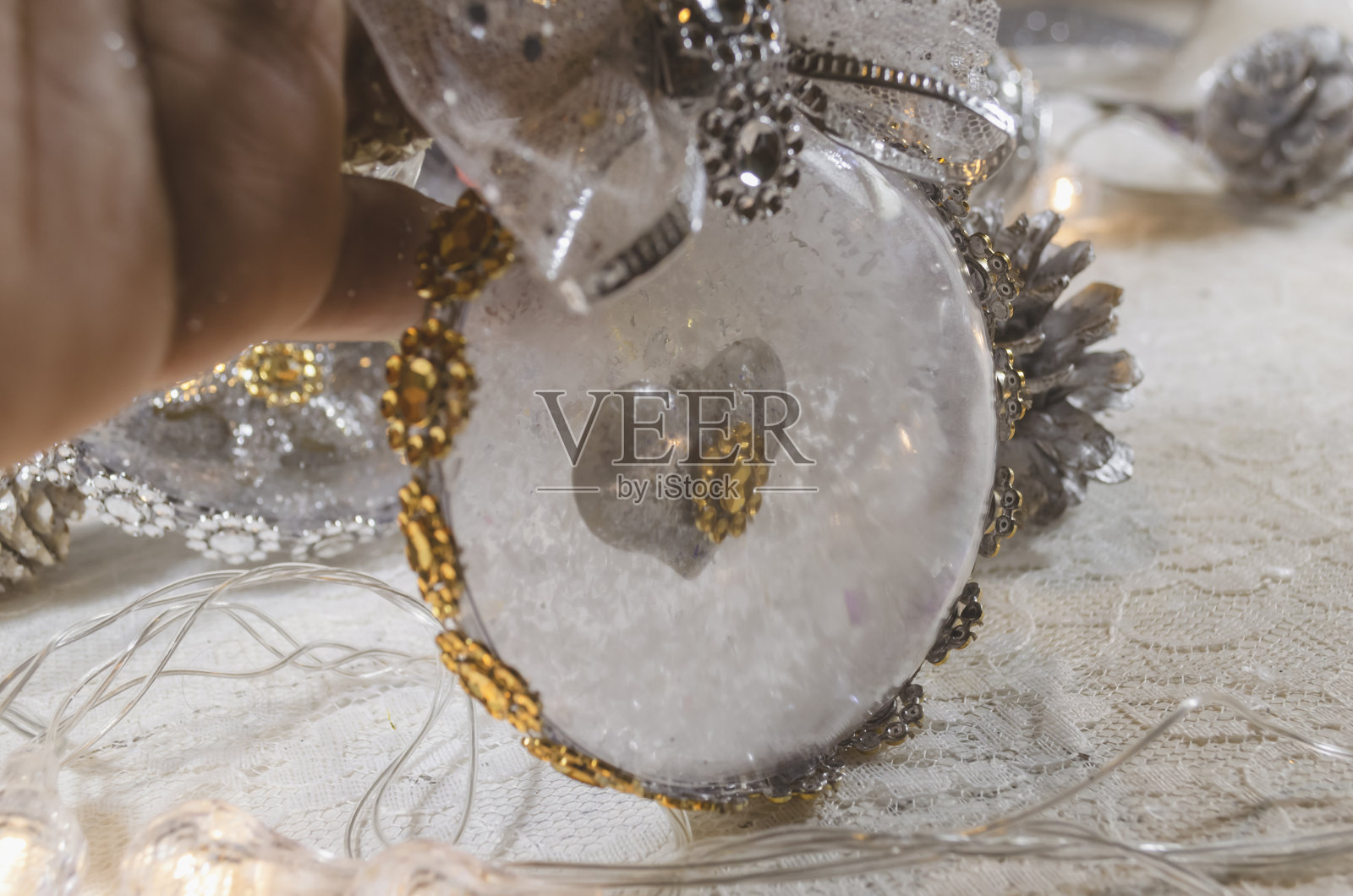里面是透明的圣诞球，里面是一颗心，上面装饰着一个金和银的蝴蝶结照片摄影图片