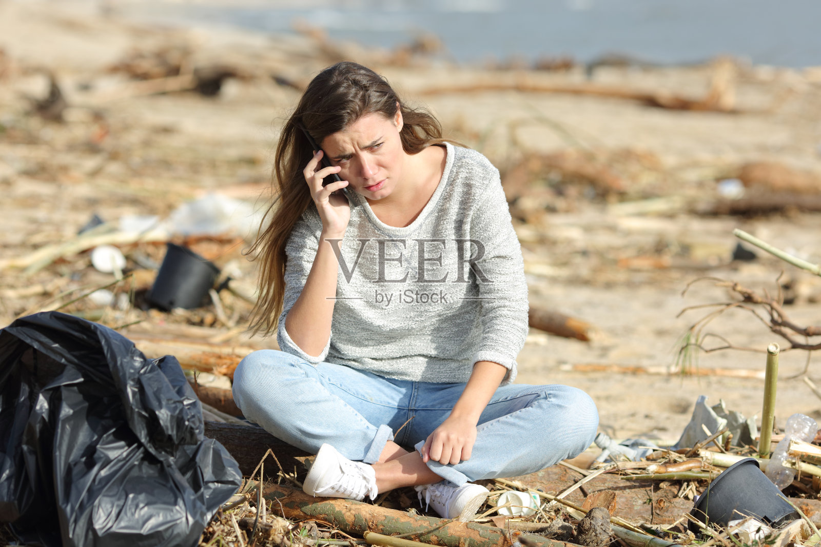 一名正在清理海滩的志愿者打来了电话照片摄影图片