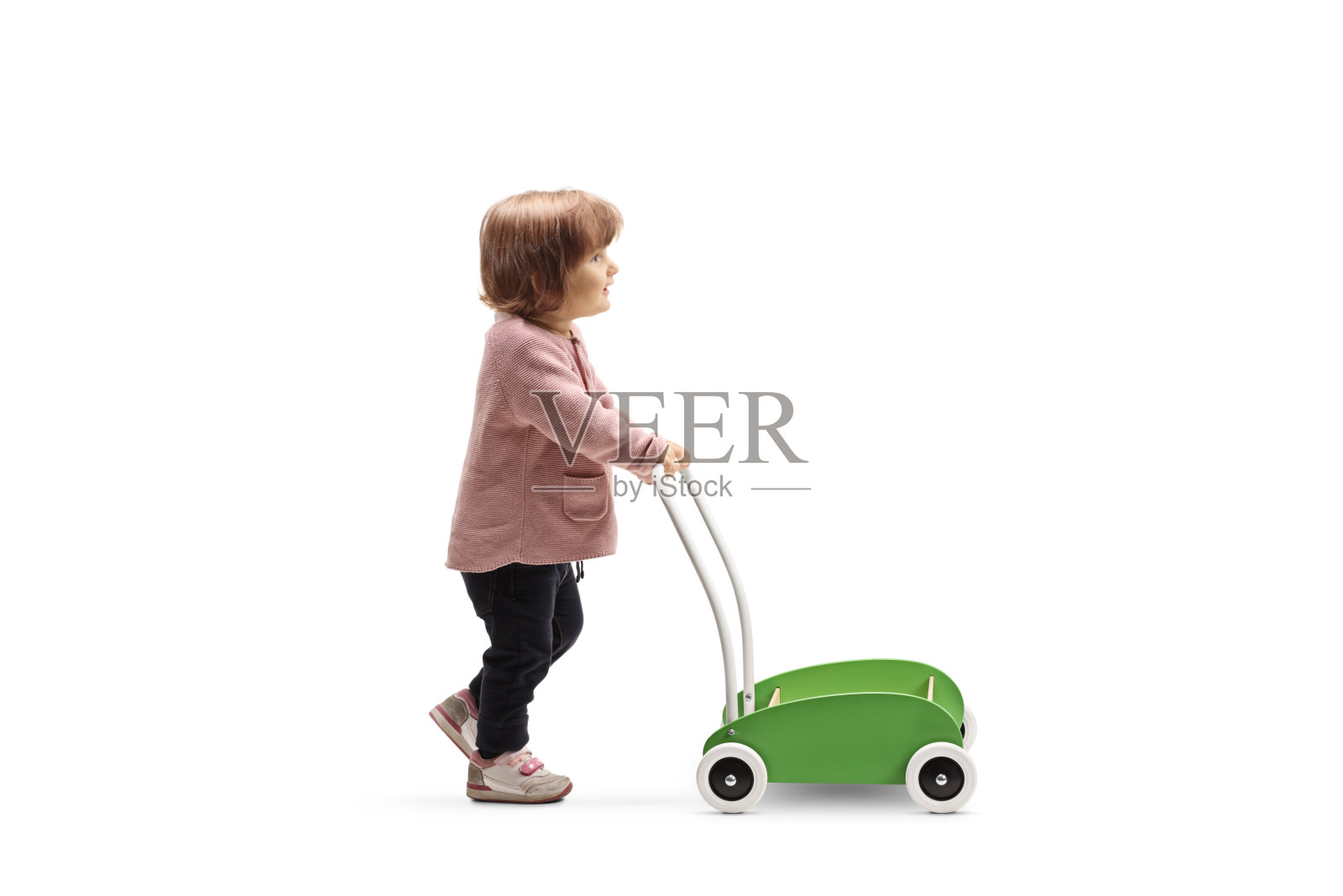 一个蹒跚学步的女孩推着一辆玩具车的完整的侧面照片照片摄影图片