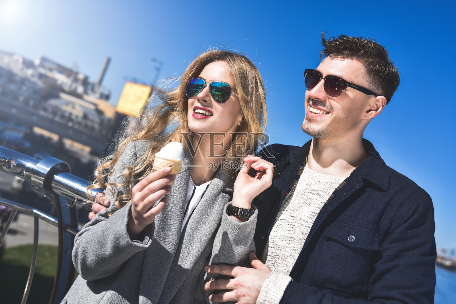 一对戴着太阳镜的幸福浪漫的白人夫妇。有趣的女孩吃了冰淇淋照片摄影图片