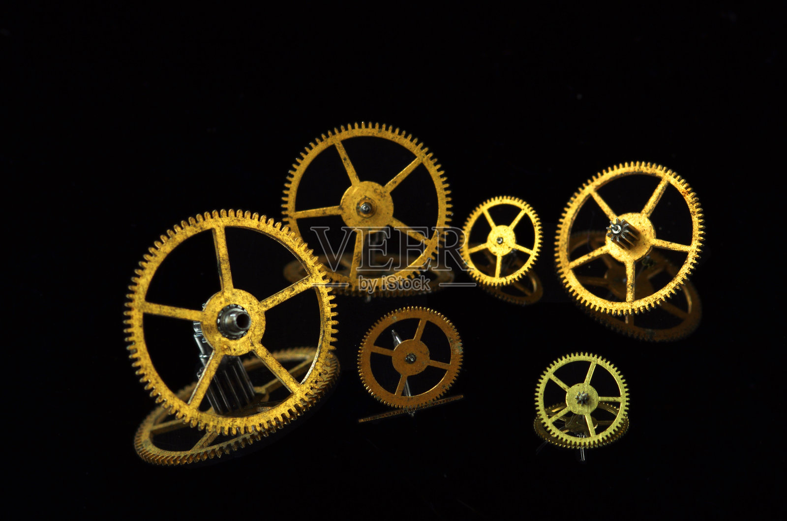 几个齿轮由黄色金属在黑色照片摄影图片