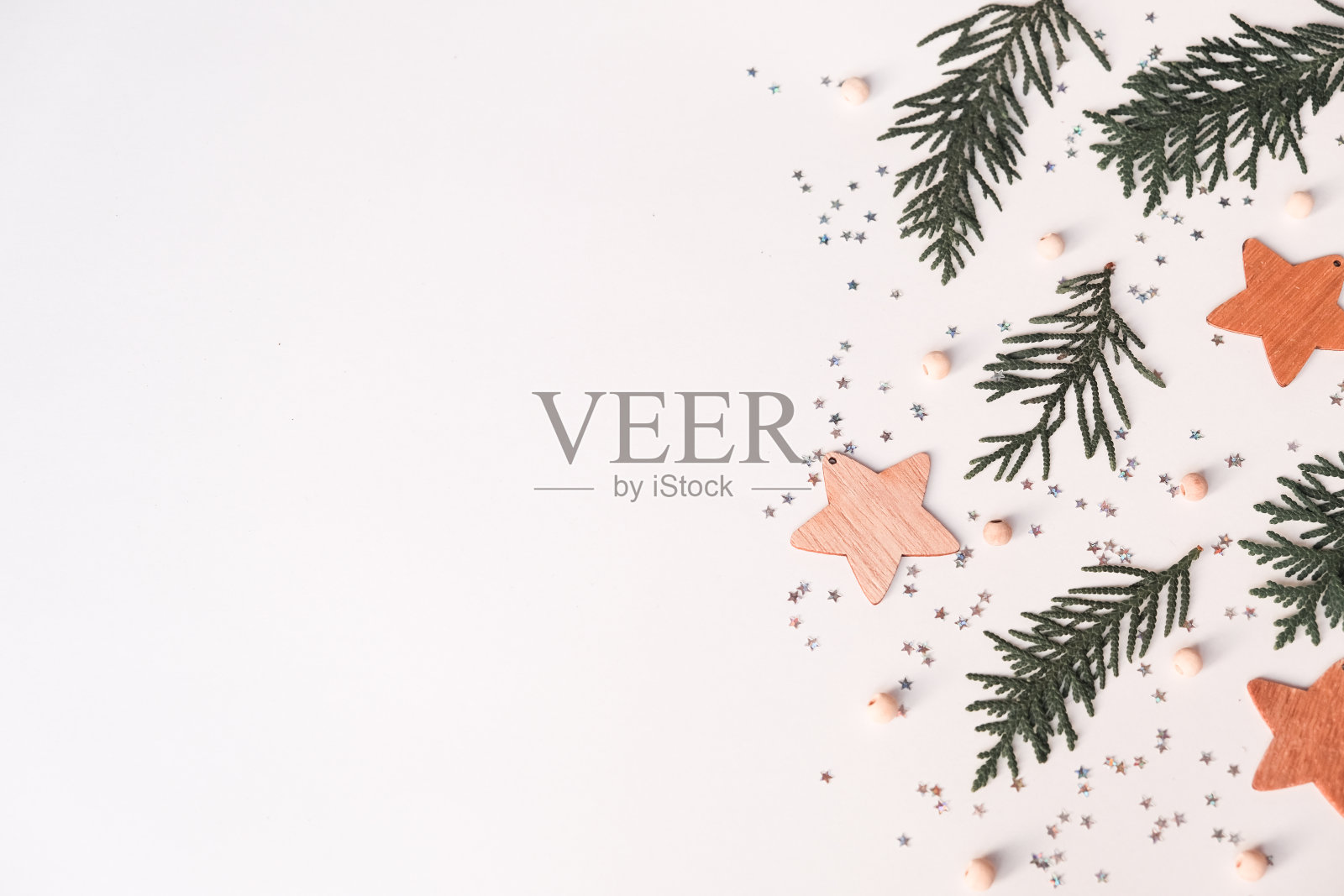 圣诞节冬季组成。木质的星星，冷杉树枝和闪烁在白色的背景。俯视图，平放照片摄影图片