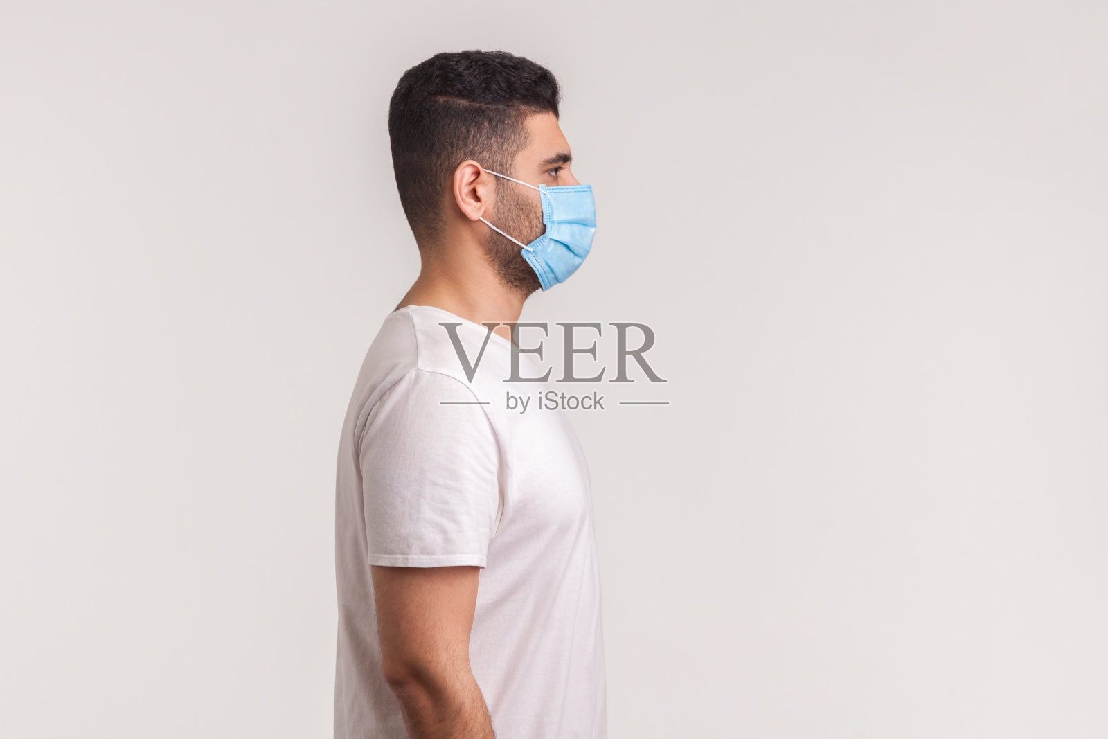 佩戴卫生口罩以预防感染、流感、新型冠状病毒等呼吸道疾病的男子侧面图照片摄影图片