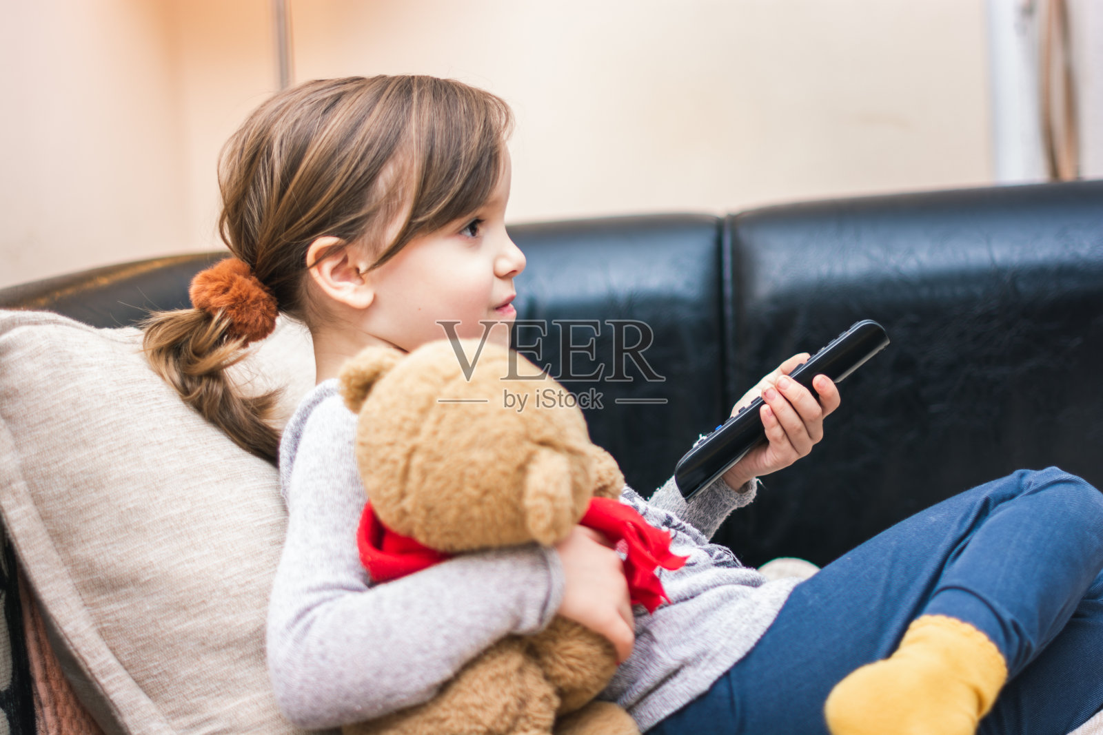 微笑的女孩在沙发上看电视照片摄影图片