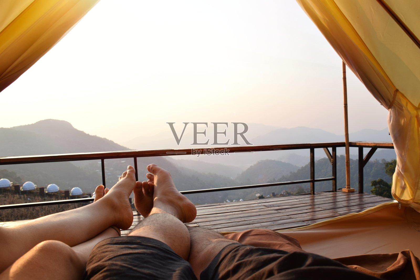 一对夫妇睡在帐篷里，早上看山景。假期放松的概念。照片摄影图片