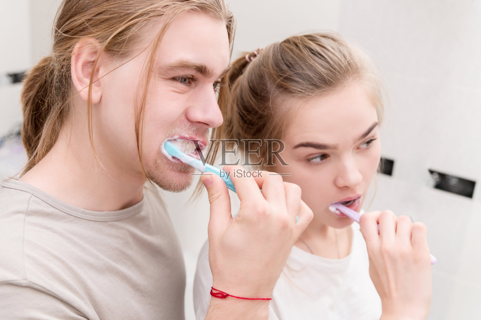 年轻夫妇在洗澡时一起刷牙，照镜子。特写镜头照片摄影图片