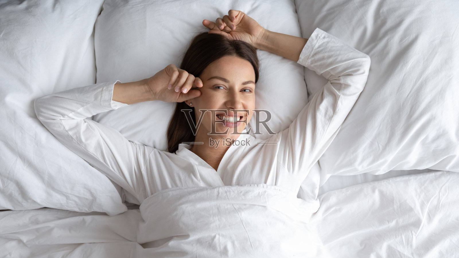 头像微笑美丽的女人躺在舒适的床上照片摄影图片