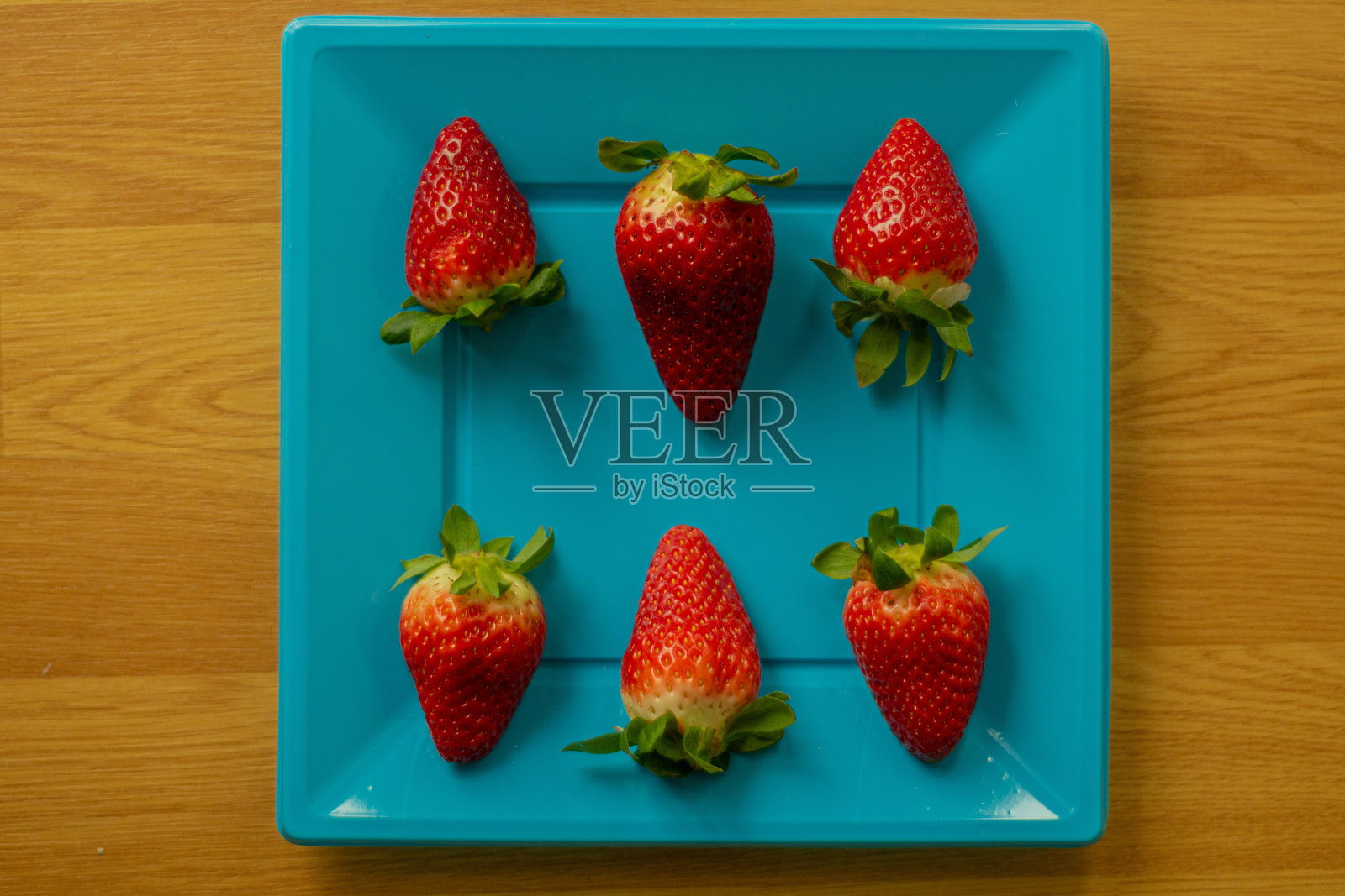 蓝色盘子上的草莓特写照片摄影图片