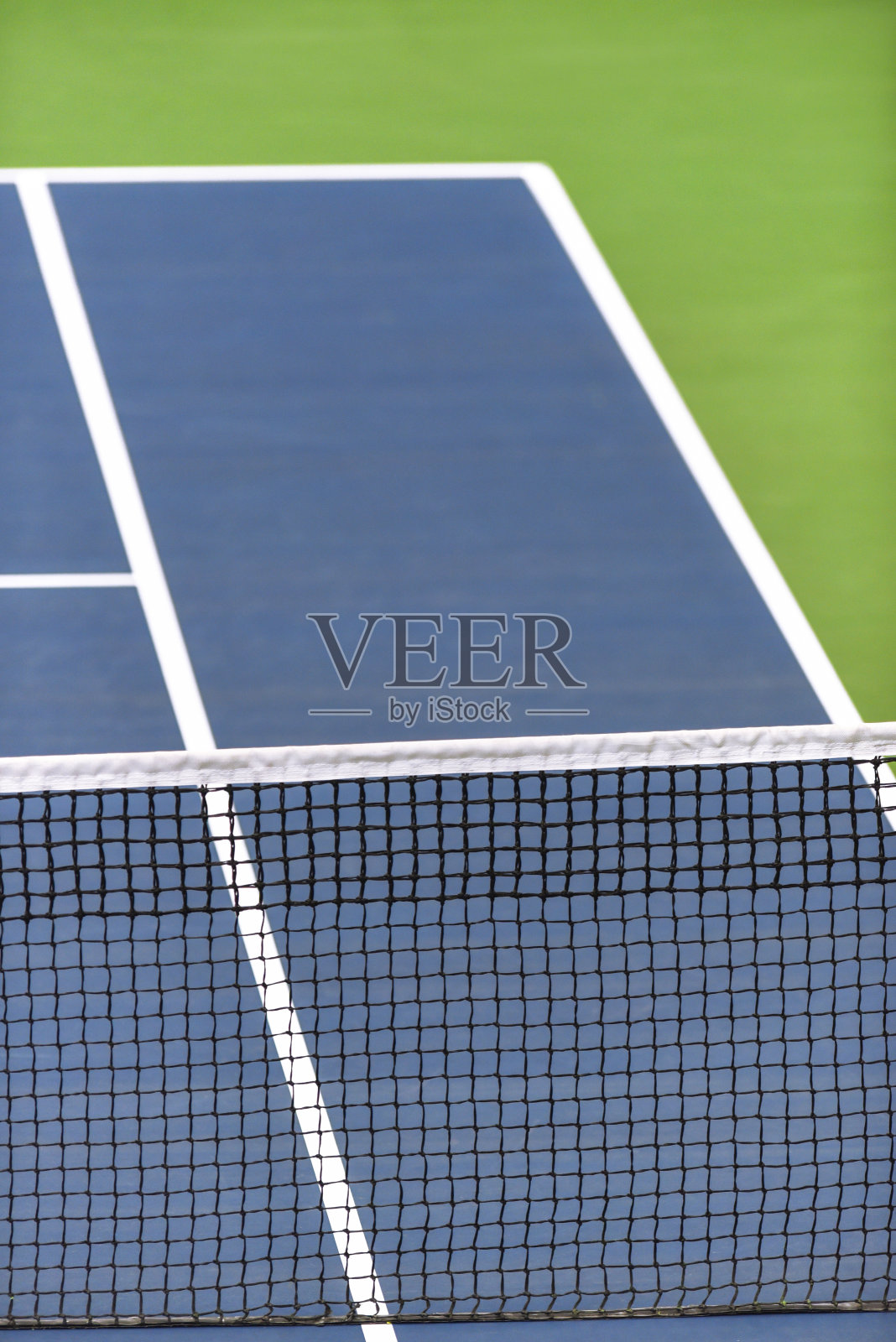 在蓝绿色场地上的网球网照片摄影图片