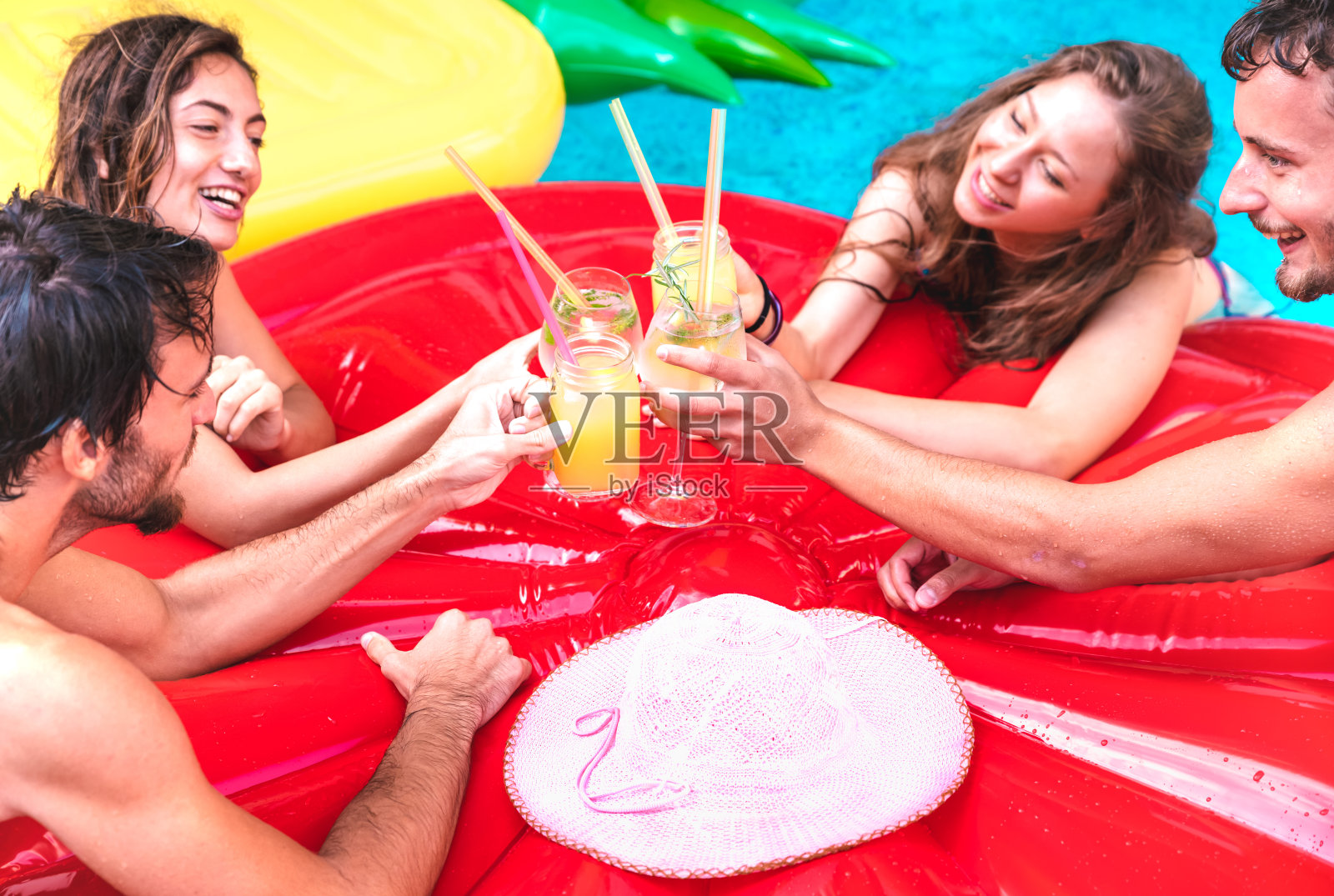 年轻的人喝水果鸡尾酒在泳池派对-豪华度假概念与男孩和女孩在夏天在酒店度假-快乐的朋友在热带海滩欢呼照片摄影图片