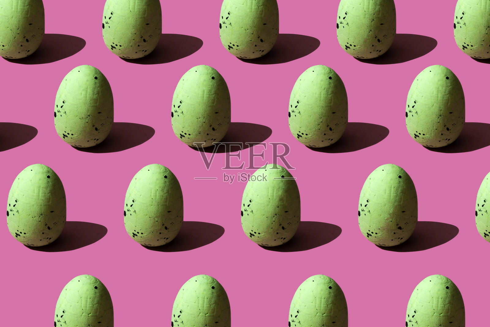 以绿色鹌鹑蛋为背景，配以强烈的灯光阴影。复活节的设计照片摄影图片