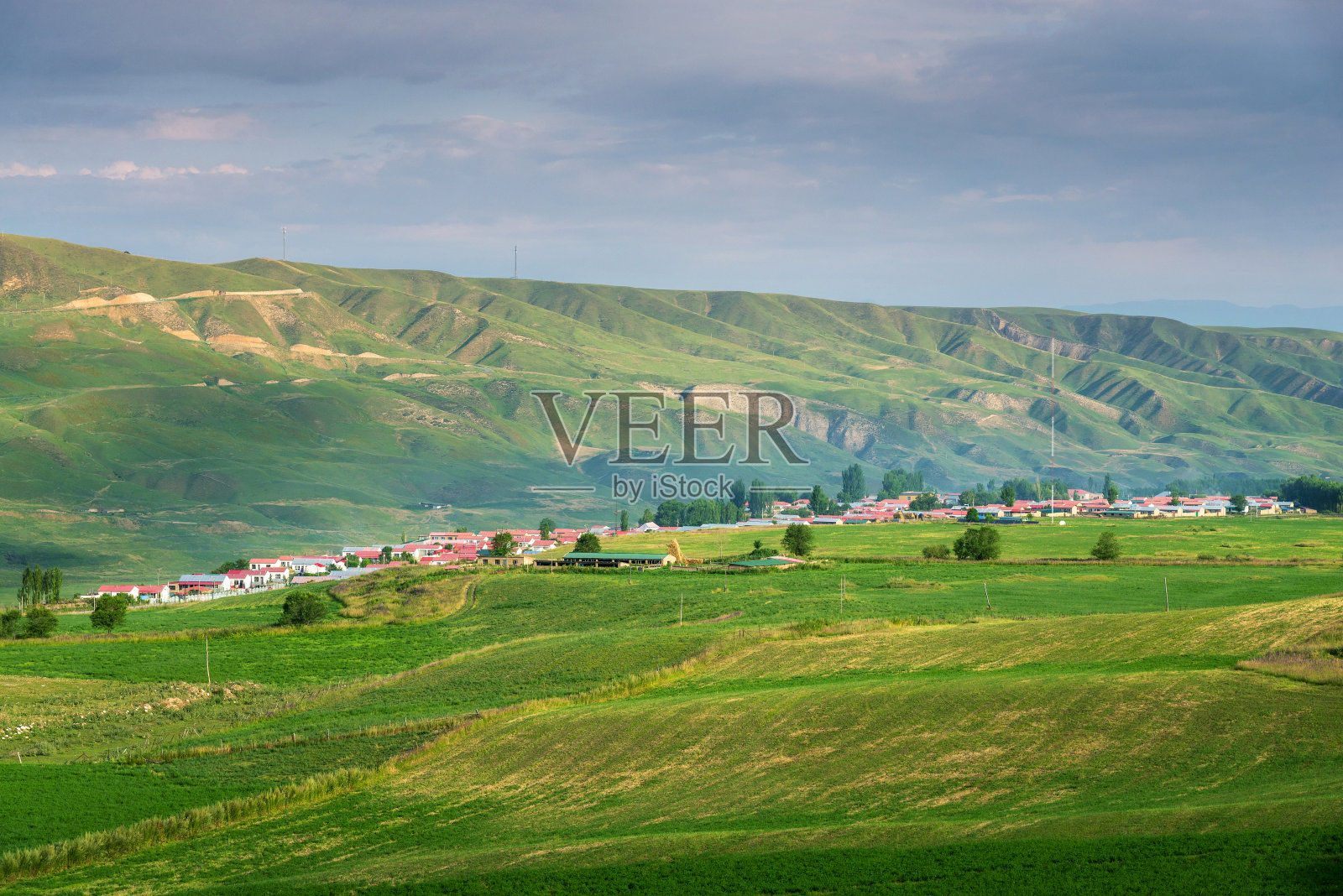 山谷中的田园村庄，前景是农田照片摄影图片