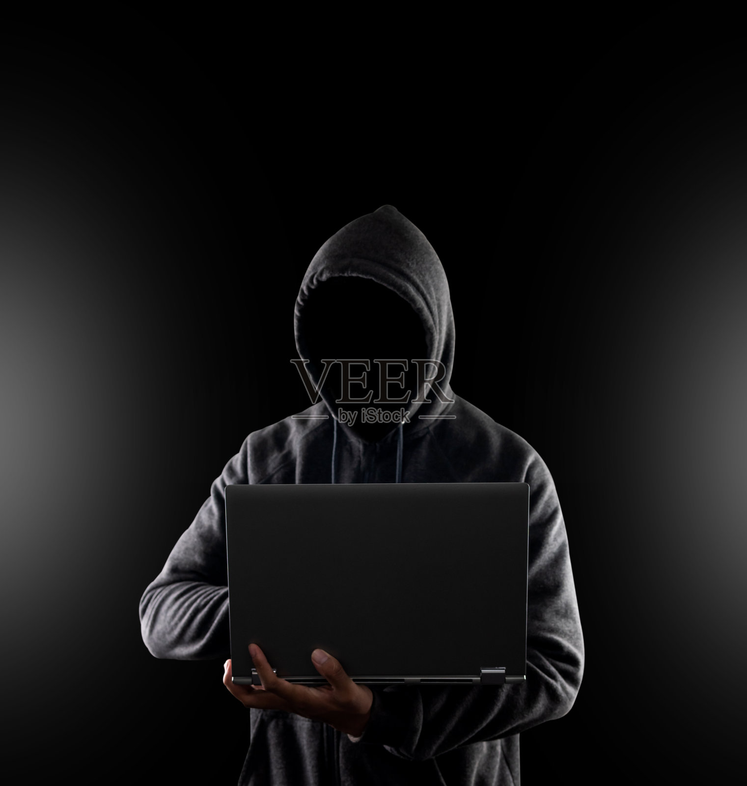 网络犯罪，黑客攻击和技术犯罪。黑色背景的笔记本电脑上没有黑客的脸照片摄影图片