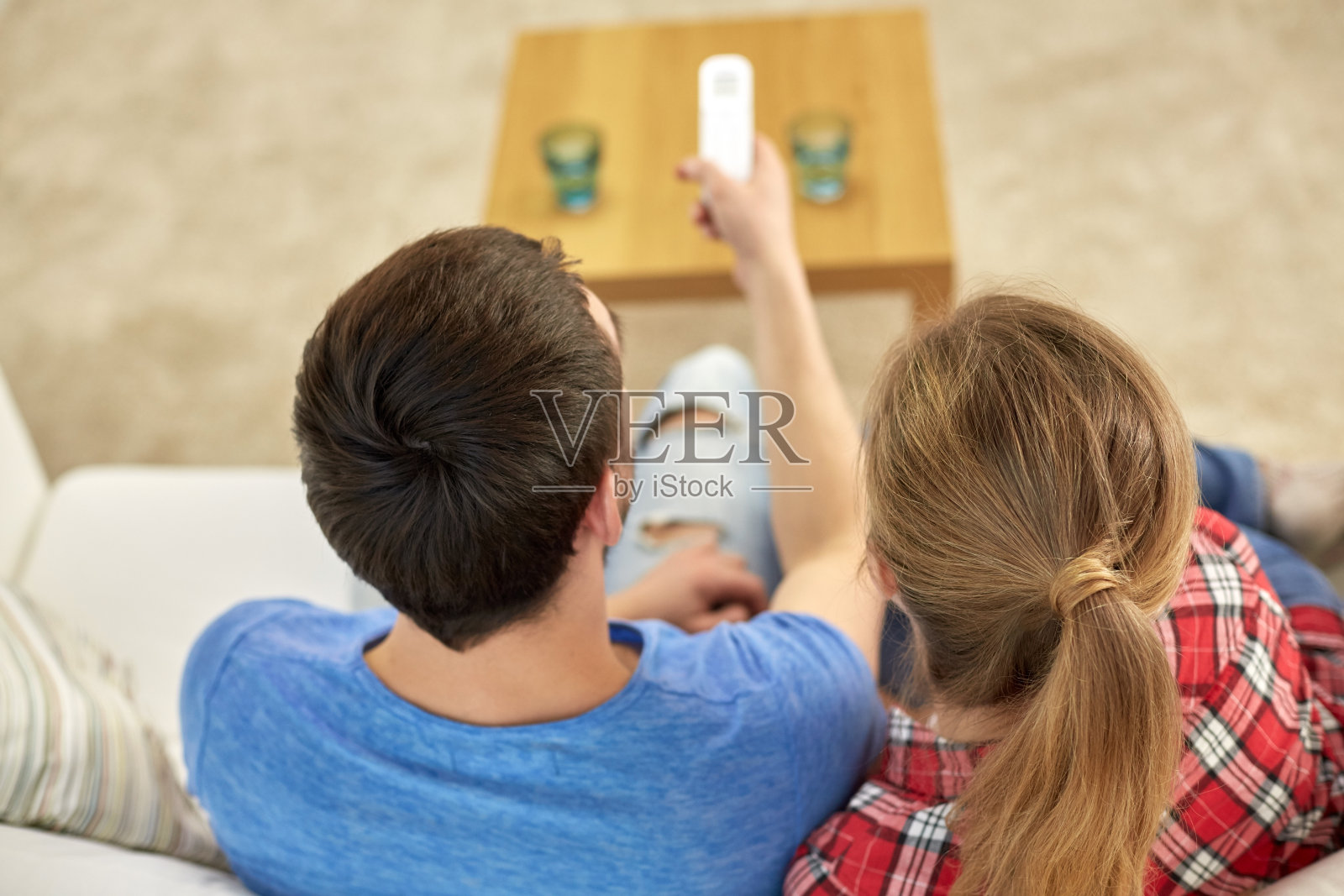 近距离的夫妇与遥控器看电视在家里照片摄影图片