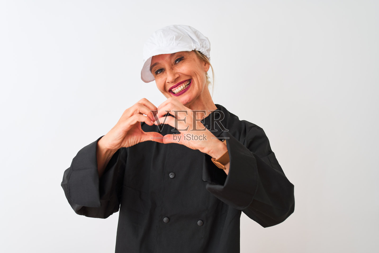 中年厨师女人穿着制服和帽子站在孤立的白色背景微笑在爱显示心形符号和形状的手。浪漫的概念。照片摄影图片