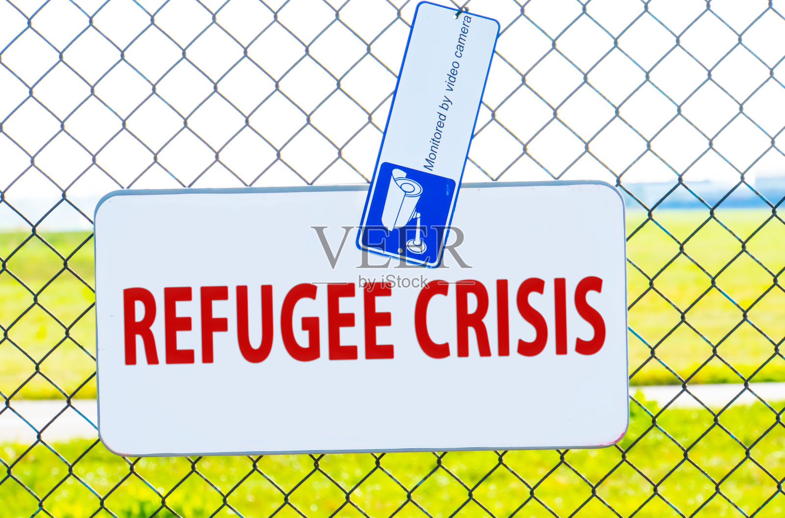 显示难民危机的文字标志。概念性照片指的是运动的大群流离失所的展示。栅栏上的红色标志照片摄影图片