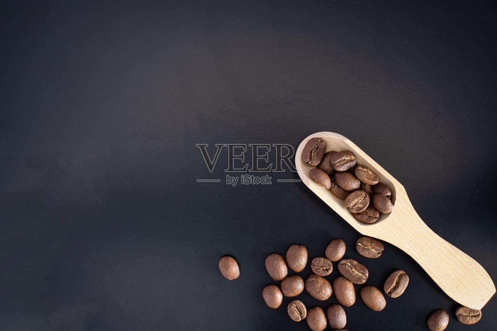 咖啡豆在一个旧木勺上深色背景文字复制空间照片摄影图片