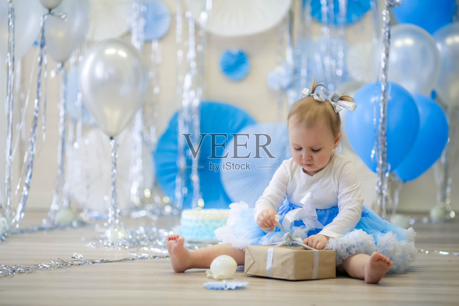 欢快的儿童生日小女孩的背景是蓝色的空气和蓝色的纸莎草圆圈照片摄影图片