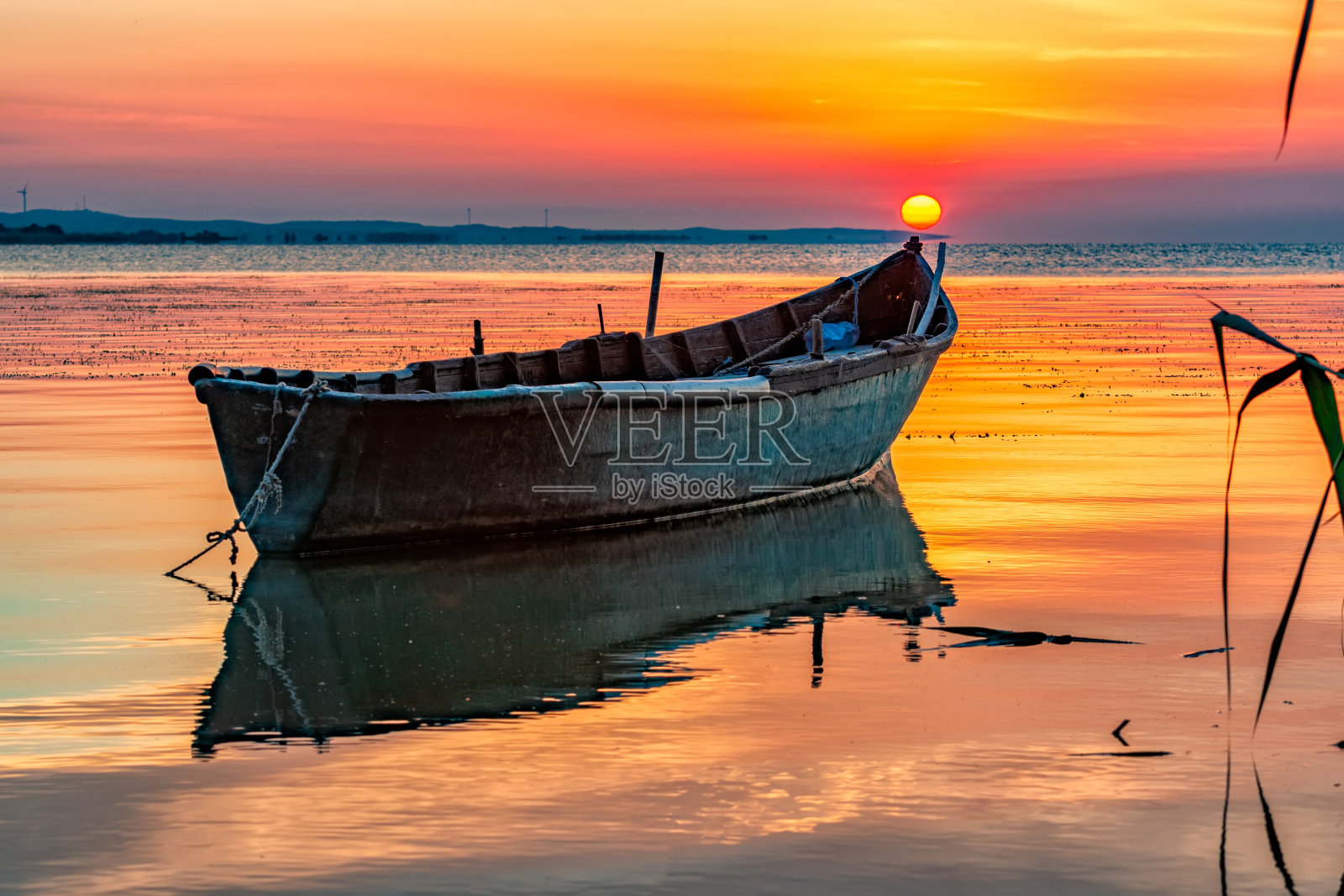 美丽的日出，小船倒映在湖上照片摄影图片
