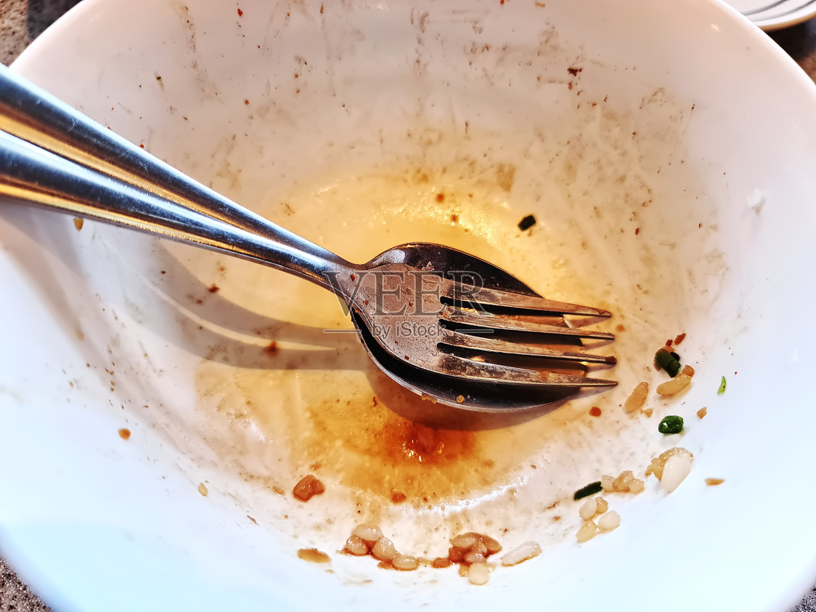 特写勺子和叉子在白色碗与食物剩余照片摄影图片