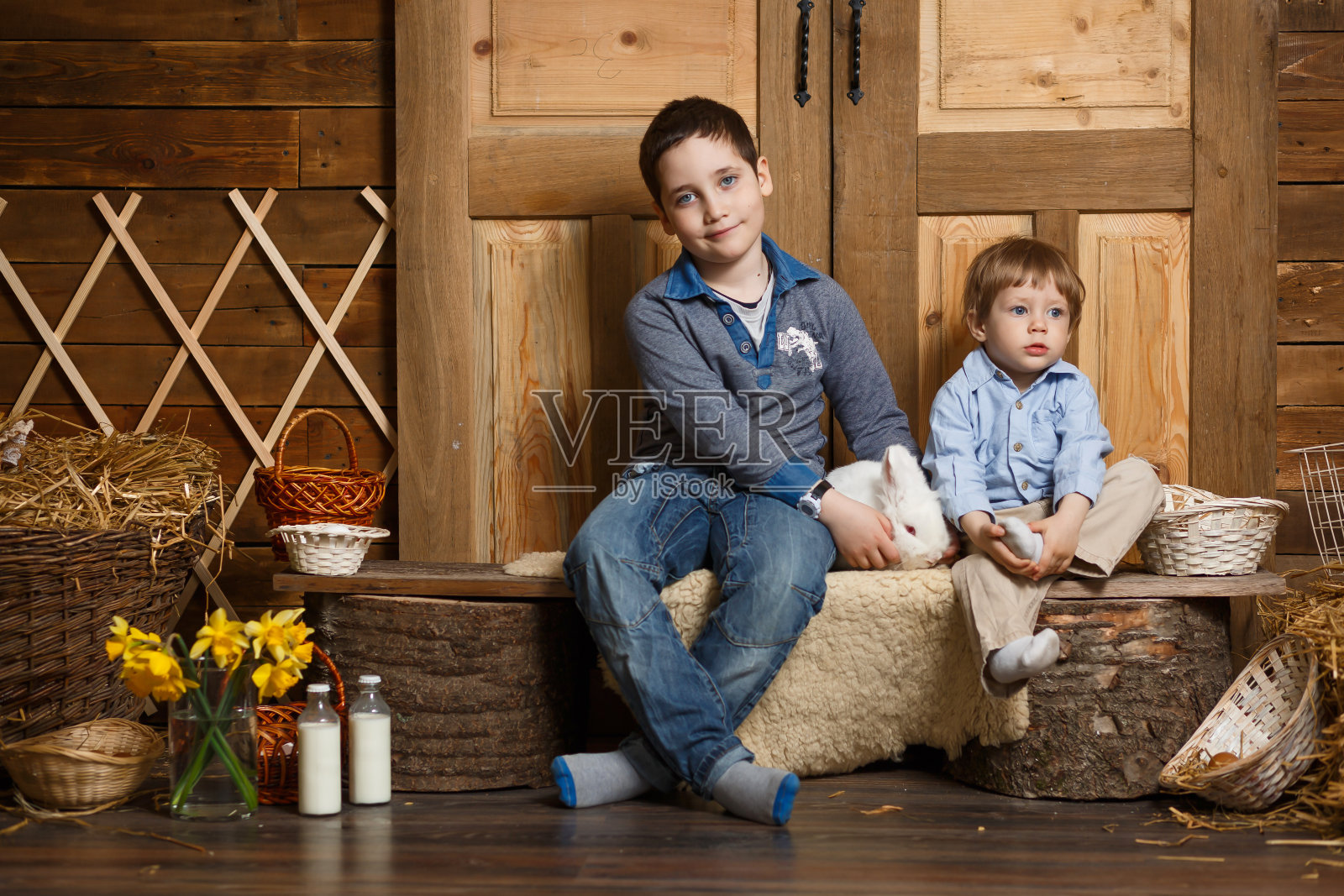 两个小孩和小白兔坐在一张木桌上照片摄影图片