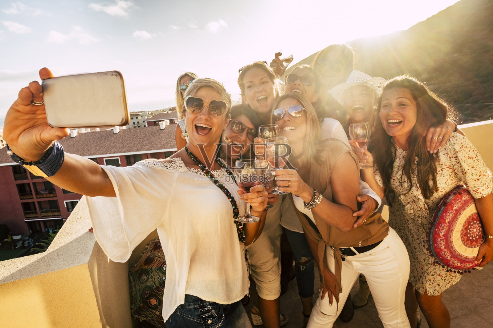 一群快乐和愉快的年轻女性在户外聚会一起用手机自拍照片-人们庆祝与友谊的葡萄酒和敬酒-美丽的白人女性笑照片摄影图片