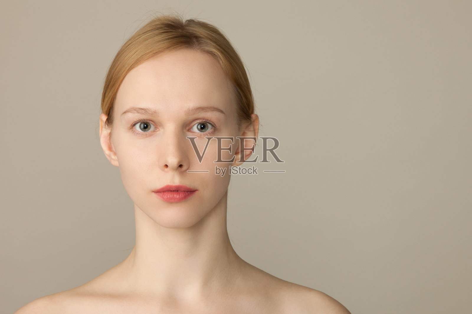 一个25岁女人的画室肖像，米色背景照片摄影图片