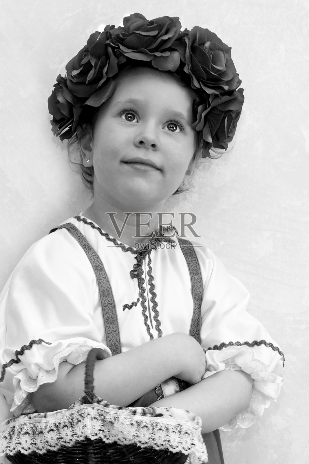 女孩5岁，欧洲和俄罗斯民族服装。一件太阳裙和一件白色衬衫，头上戴着花环，提着一个柳条篮子照片摄影图片