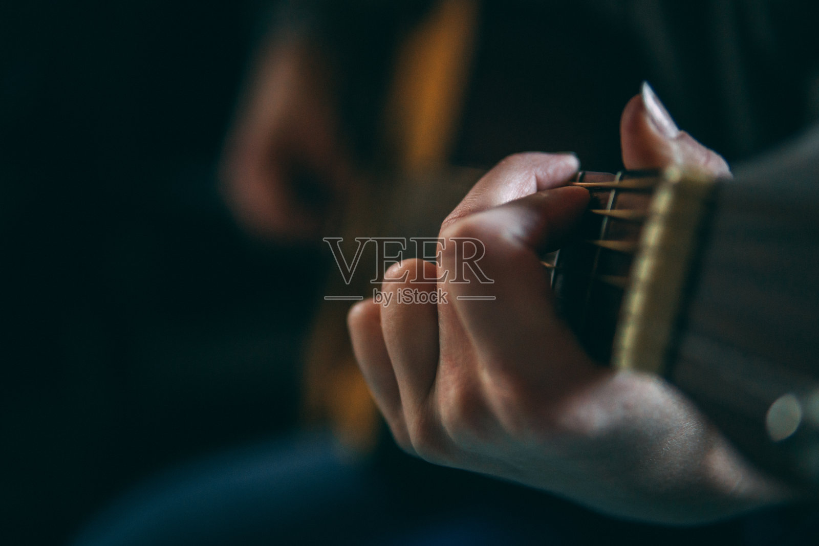 女人的手在弹奏原声吉他，拿着和弦靠近照片摄影图片