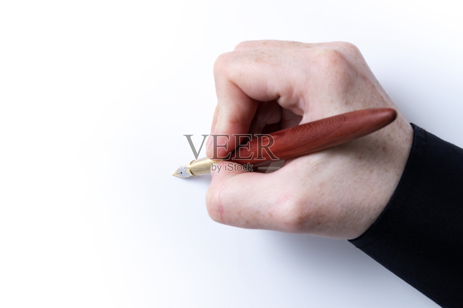 手握钢笔俯视图与黑衬衫上的白色背景和窄焦点照片摄影图片