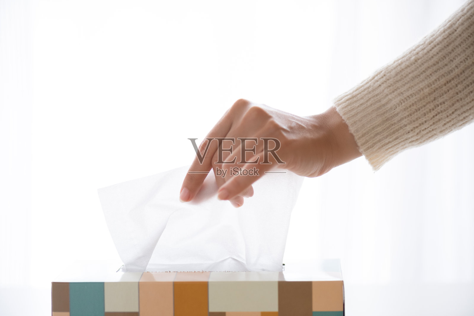 女人用手从纸巾盒里挑出白色的纸巾。医疗保健的概念。照片摄影图片