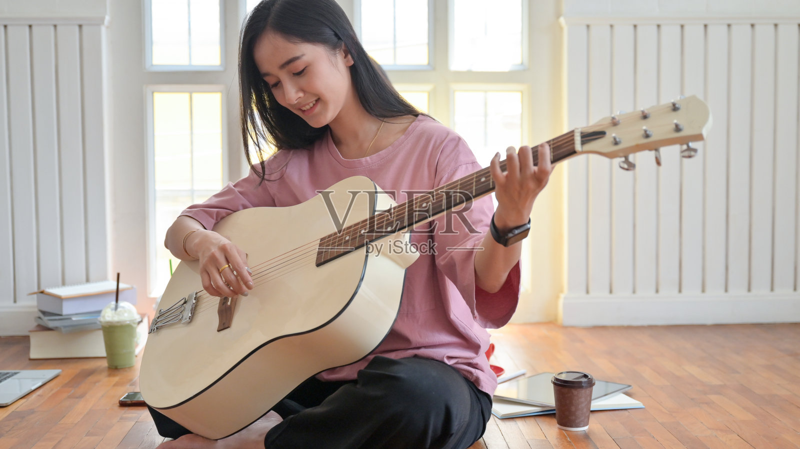 一名少女在隔离新冠病毒期间在家弹吉他。照片摄影图片