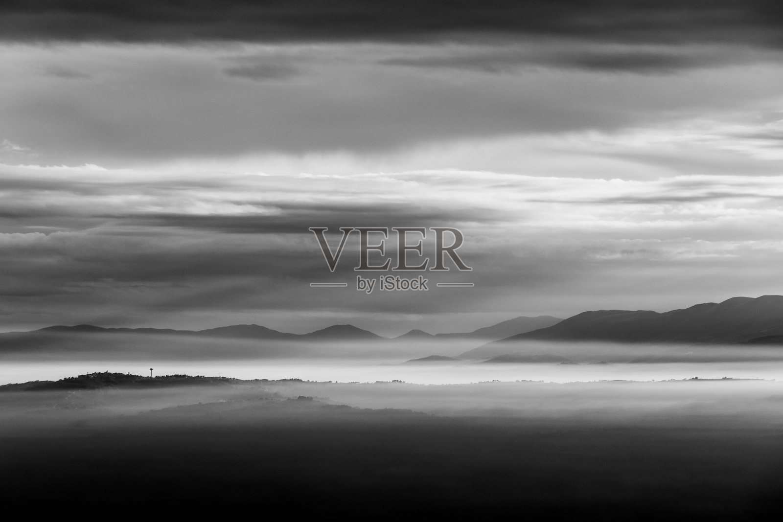 在翁布里亚(意大利)，雾气弥漫着山谷，山上和小山层层堆积照片摄影图片