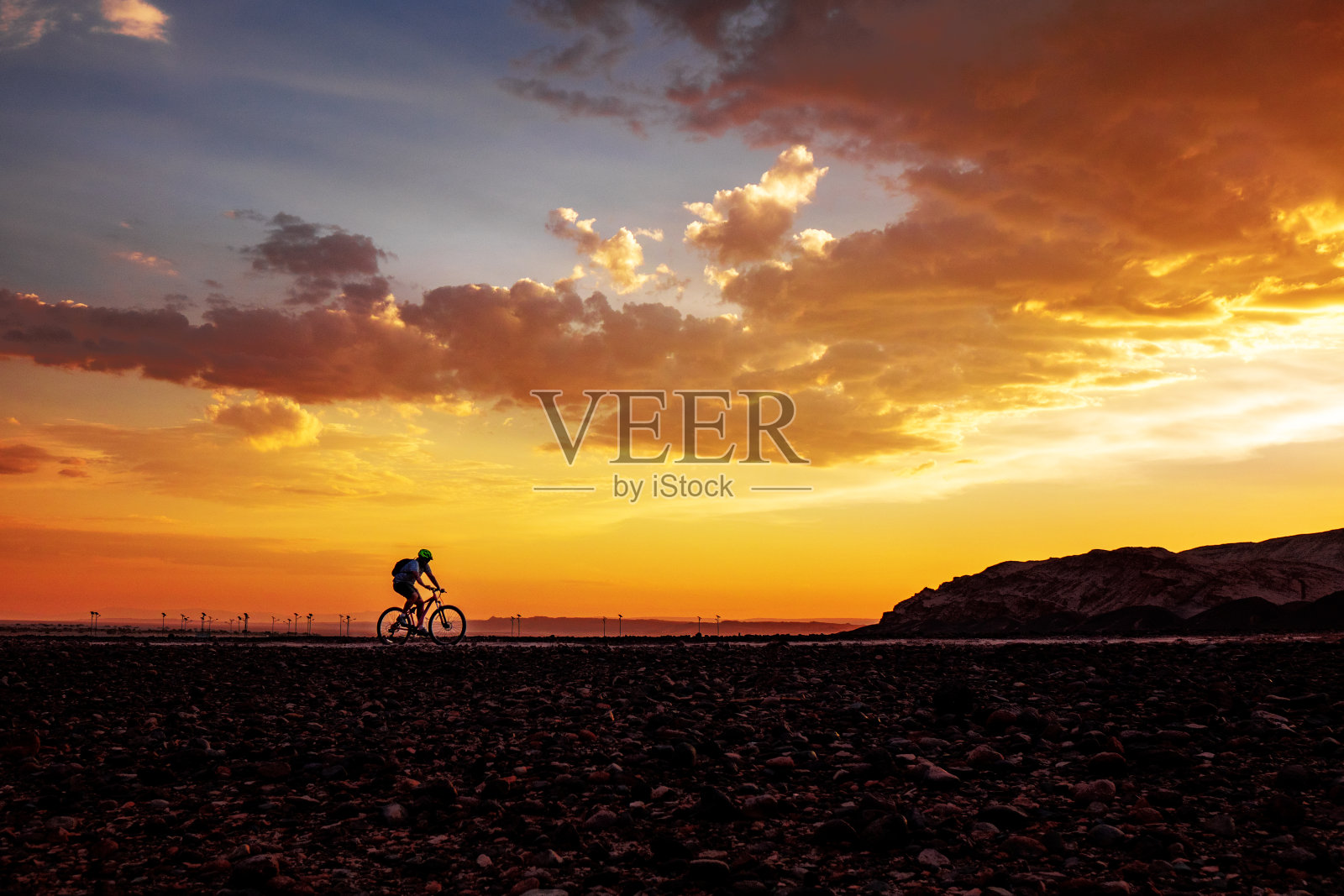 在美丽的日落背景上骑自行车的人的剪影照片摄影图片