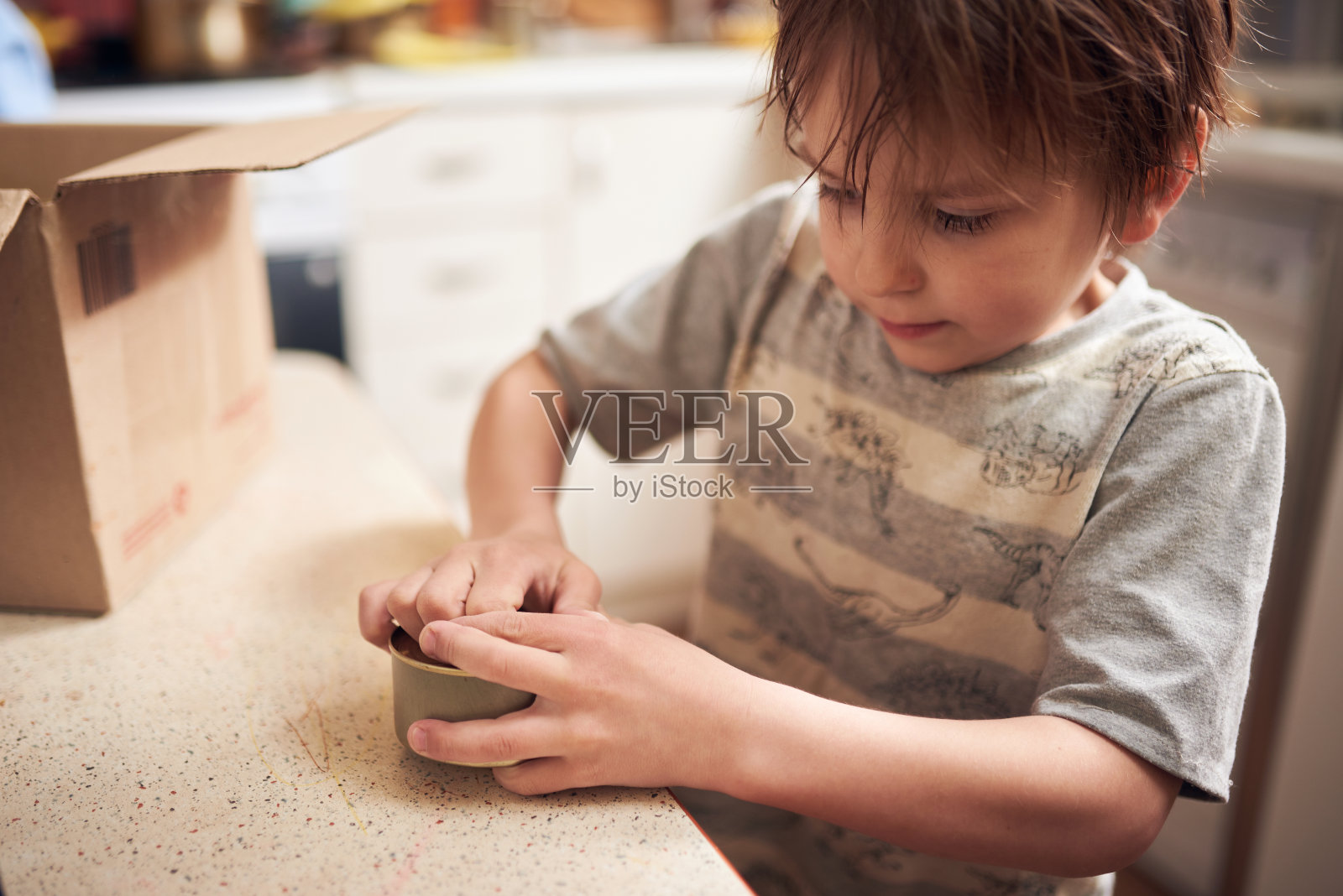 可爱的学前班男孩在隔离期间在家里厨房打开一个罐头照片摄影图片