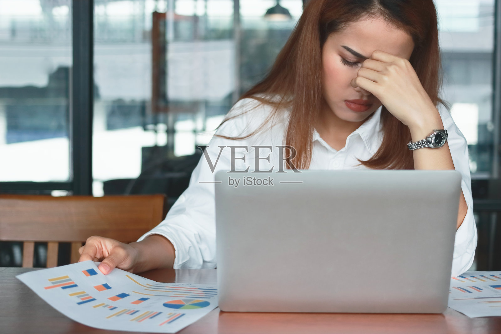 疲惫紧张的年轻亚洲女商人在工作场所遭受严重的抑郁症。照片摄影图片