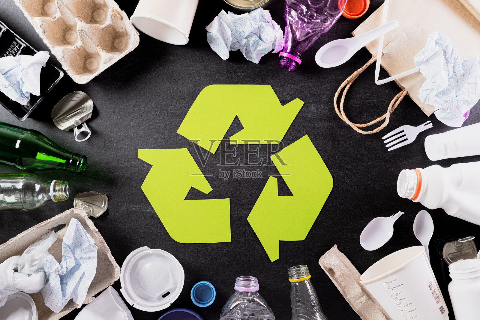 俯视图不同的垃圾材料与回收符号在黑色背景。回收，世界环境日，绿色和生态概念照片摄影图片