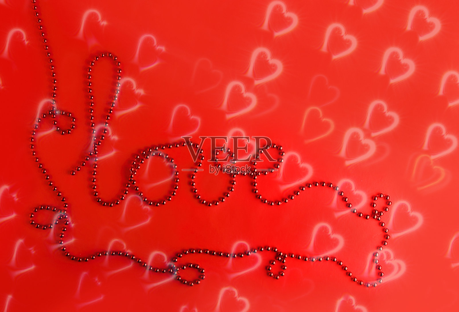 红红。珠桌上，文字取自珠上的“爱”字。抽象的背景，心的轮廓。照片摄影图片