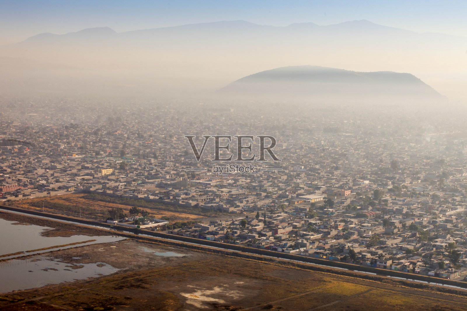 污染和烟雾笼罩着墨西哥城东南部的一个人口稠密地区照片摄影图片