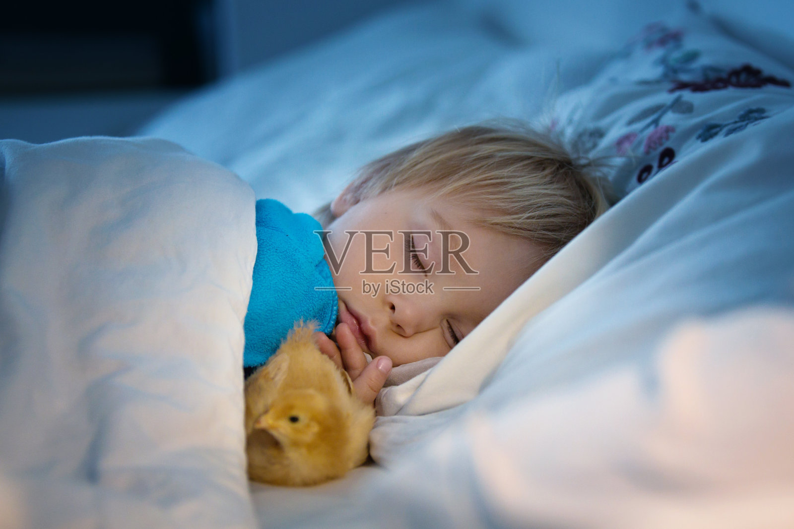 一个蹒跚学步的小孩，和一个小妞睡在床上照片摄影图片