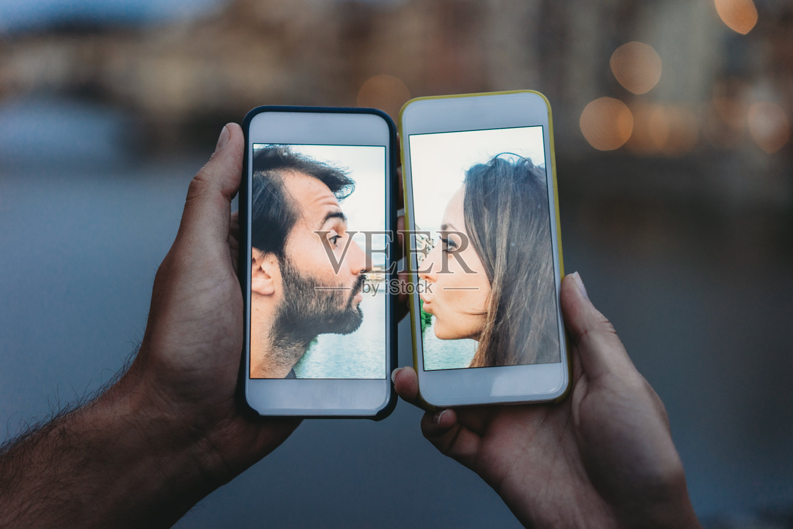 年轻情侣通过手机接吻-社会距离概念照片摄影图片