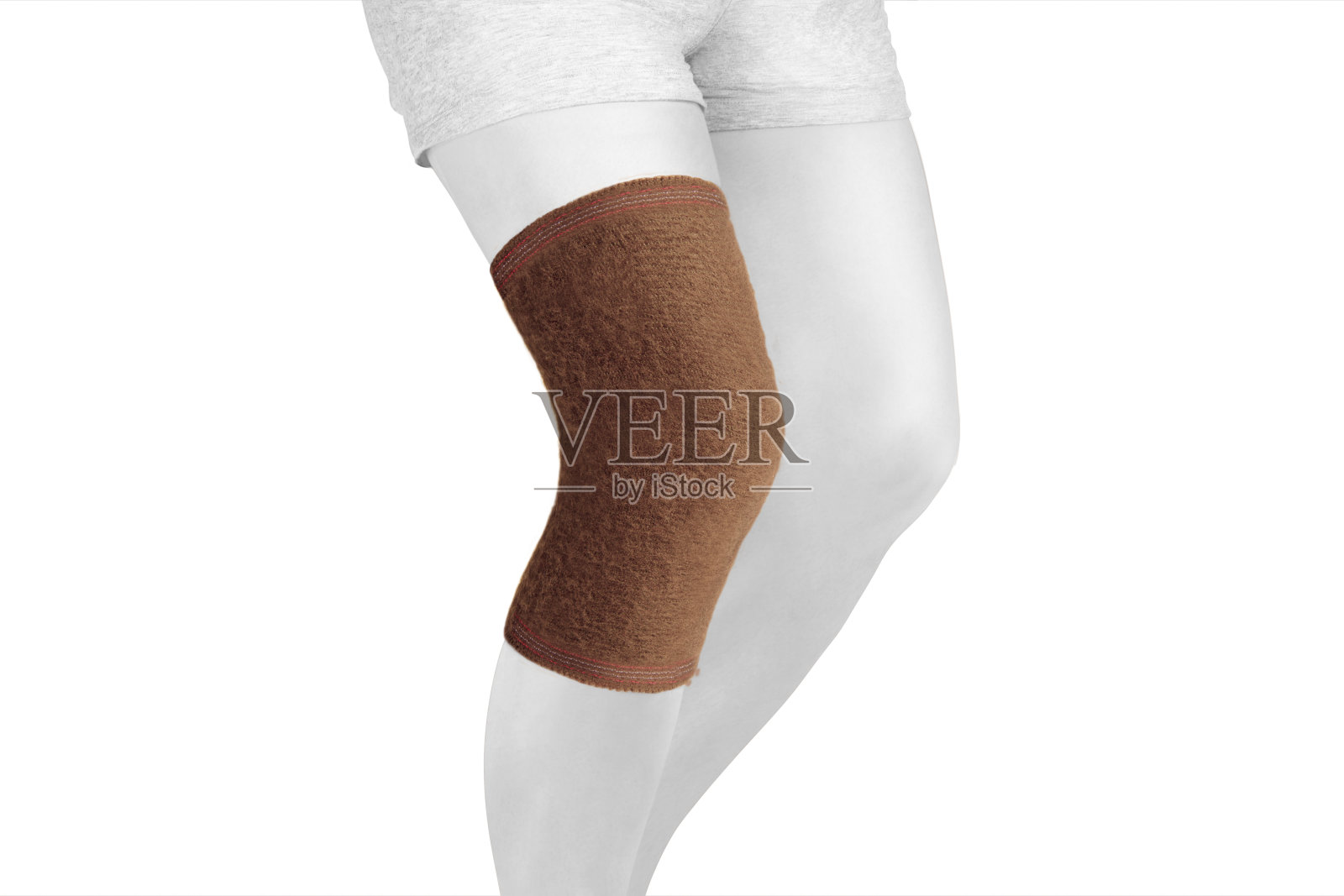 腿上的膝盖支撑支架孤立在白色背景上。整形外科解剖矫正法。用于膝关节固定、损伤和疼痛的支架。矫正器。脚矫正法。膝关节绷带袖。弹性运动照片摄影图片