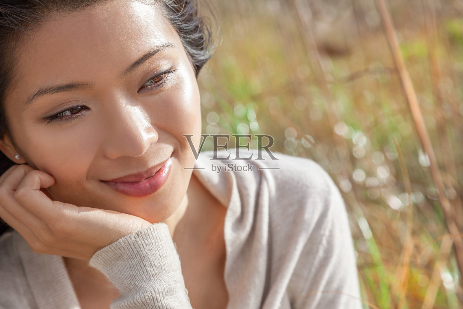 一个美丽的年轻的中国亚洲妇女的肖像在她的手休息照片摄影图片