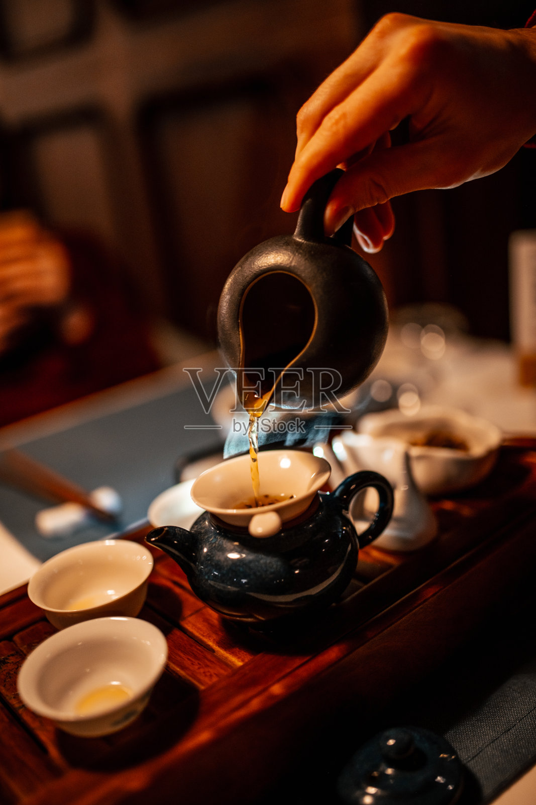 中国茶道。茶，手和茶壶的特写。自然光线照片摄影图片