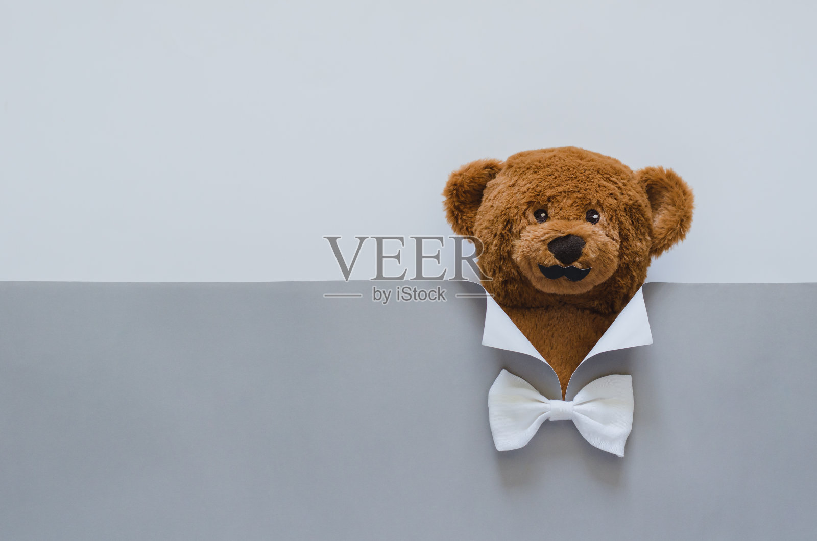 带胡子的泰迪熊封面是用灰色的纸做的套装。照片摄影图片