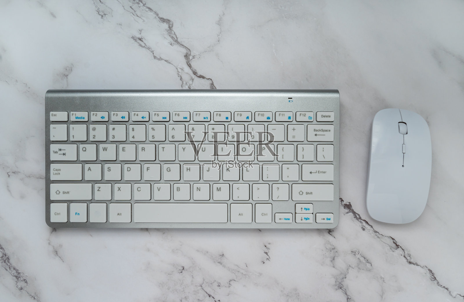 电脑键盘和鼠标隔离在白色大理石背景。顶部视图与复制空间。平的。办公室的概念照片摄影图片