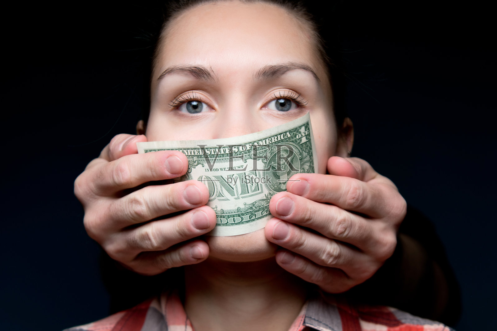 金钱使女人沉默。用一张一美元的钞票捂住嘴照片摄影图片