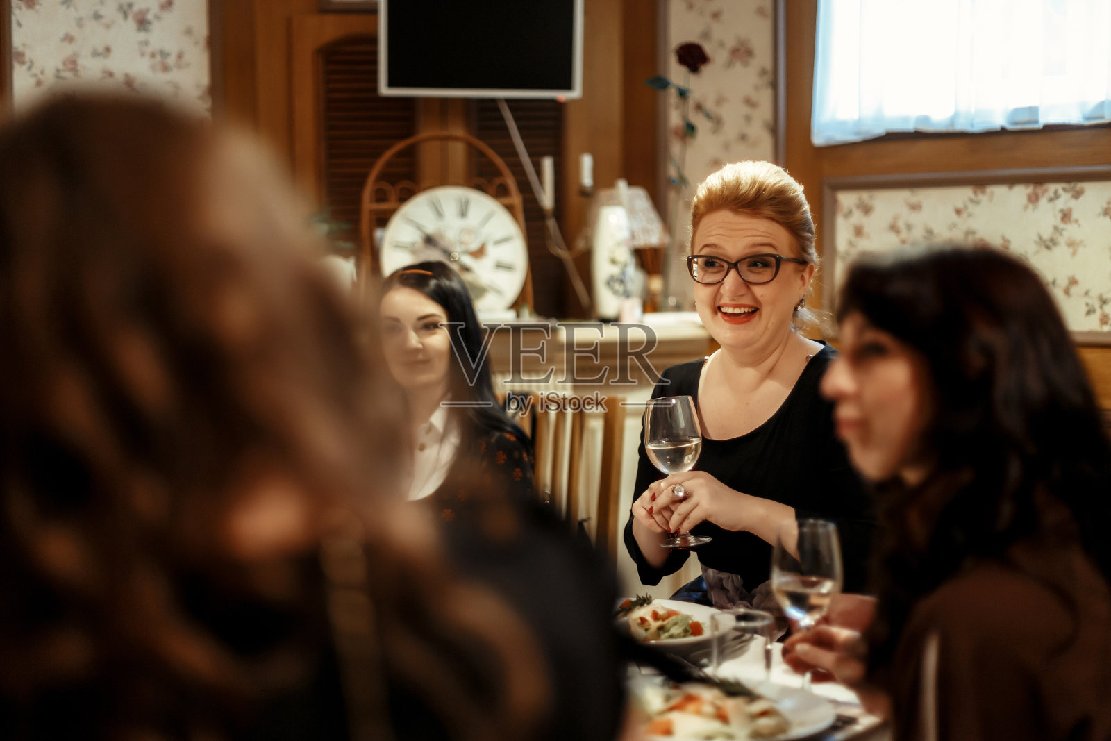 一群奢华优雅的女士在豪华的餐厅里喝着香槟，笑着庆祝照片摄影图片