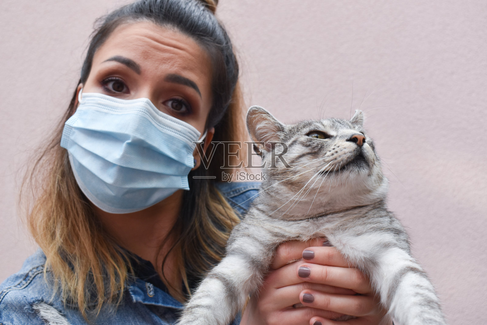 一个带面罩的妇女在户外抱着一只猫照片摄影图片
