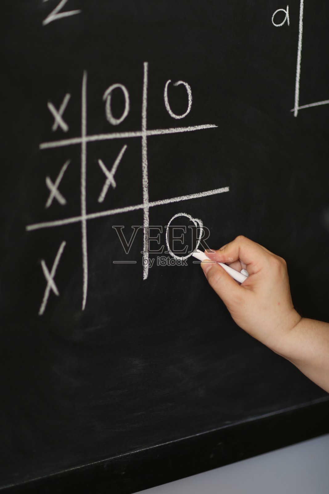 手持粉笔，在黑板上写下复杂复杂的数学公式。照片摄影图片